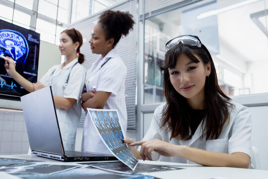 Female medical student study in class room. medical students studying human brain disease diagnosis through learning from X-ray film. Learn about brain surgery for diagnosis.