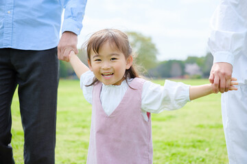 Fototapeta premium 公園で手を繋ぐ親子