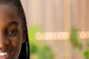 Portrait of happy african american teenager girl looking at camera and smiling with copy space