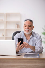 Old male employee working in the office