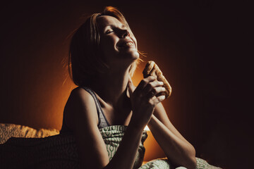 Penis concept. The woman is happy and joyful, holding in her hands a bun that looks like a male...