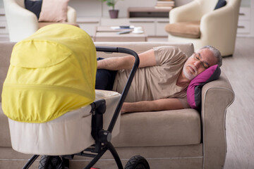 Old man looking after newborn at home