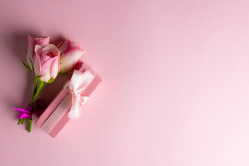 Image of pink roses and pink box with copy space on pink background