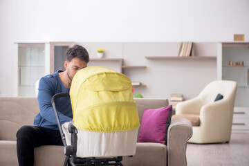 Young man looking after newborn at home