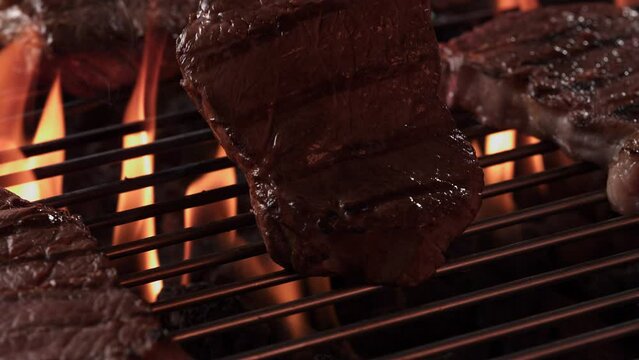 flipping a steak on fire grill