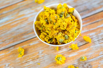 Chinese chrysanthemum flower tea - Dried chrysanthemum buds for herbal tea on wooden background, dry chrysanthemum flower yellow