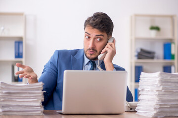 Young male employee and too much work in the office