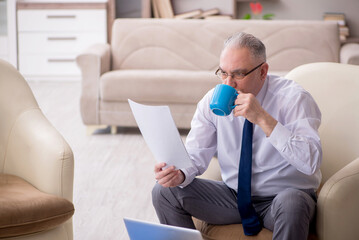 Fototapeta premium Old male boss working from home during pandemic