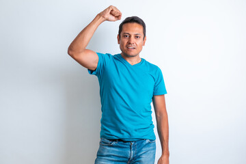 Hombre de playera azul festejando levantando el brazo con fondo blanco