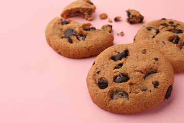Delicious chocolate chip cookies on pale pink background, closeup