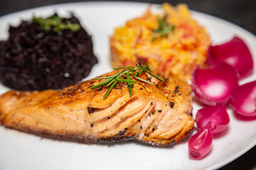 Traditional Brazilian black rice recipe with grilled salmon and pickled onions
