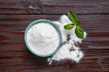 Sweet fructose powder and mint leaves on dark wooden table, flat lay