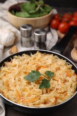 Frying pan with sauerkraut on brown table, closeup