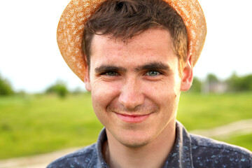 Portrait young man on nature summer background. Smiling young man. 20s years. Handsome man outdoors portrait. Lifestyle. Farmer. Out of focus