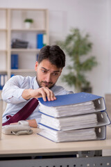 Young male employee sitting at workplace