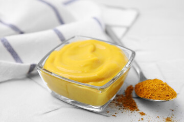 Tasty curry sauce and powder on white table, closeup