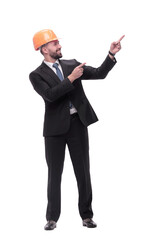 in full growth. serious businesswoman in helmet pointing somewhere to the side