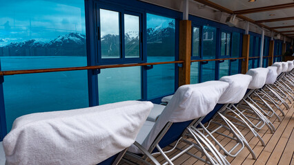Daybeds in row. Window view to coastal landscape of fjords and glaciers from resort daybeds