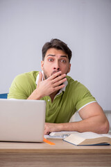 Young male student sitting in front of whiteboard