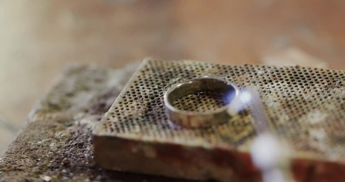 Close up of shaping ring with blowtorch in workshop in slow motion