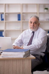 Old male employee working in the office