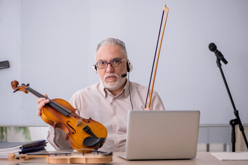 Old male music teacher in the classroom