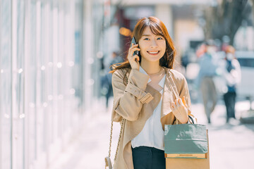 スマホで話しながらショッピングをする笑顔の日本人女性