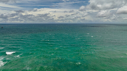 Obraz premium Blue ocean with waves and blue skies with clouds. Seascape in the tropics. Borneo, Malaysia.
