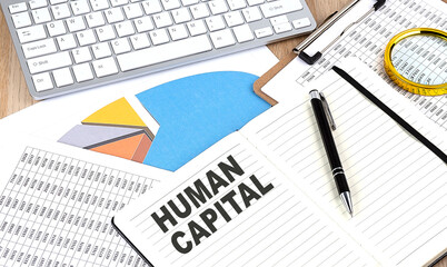 HUMAN CAPITAL text on a paper on chart background