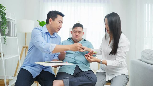 Asian happy family draw picture with young son in living room at home.