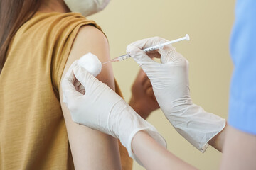 Covid-19,coronavirus hand of young woman nurse,doctor giving syringe vaccine, inject shot to asian arm's patient. Vaccination, immunization or disease prevention against flu or virus pandemic concept.