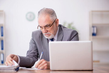 Old male employee working in the office