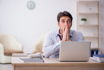 Young male employee working in the office