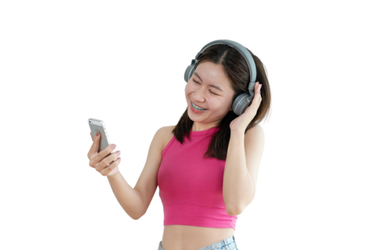 Young Asian woman happily listening to music through headphones, Girl was enjoying listening to her favorite music and rocking to the beat of the music, Stress relief, Happiness in life.