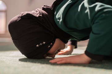 A female Muslim prayer praying inside the mosque.