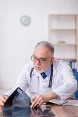 Old male doctor radiologist working in the clinic