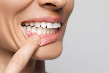 Obraz premium Woman showing healthy gums on light background, closeup. Space for text