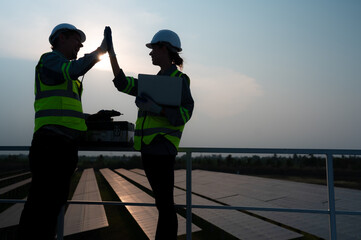 A team of electrical engineers inspecting solar panels in a hundred acres of grass on the rooftop...