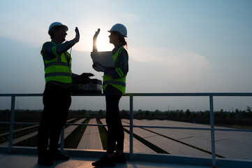 A team of electrical engineers inspecting solar panels in a hundred acres of grass on the rooftop...