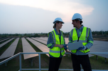 A team of electrical engineers inspecting solar panels in a hundred acres of grass on the rooftop...