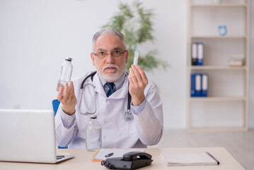 Old male doctor working in the clinic