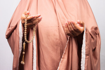 Islamic moslem woman praying with crystal tasbih wearing traditional dress