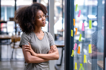 African American female student looking at memos, employee thinking about plan project workspace, memos