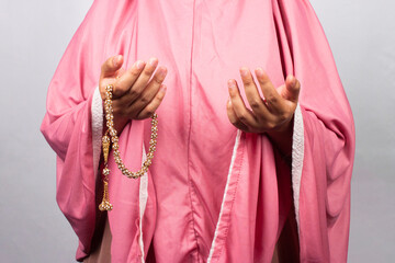 Islamic moslem woman praying with crystal tasbih wearing traditional dress