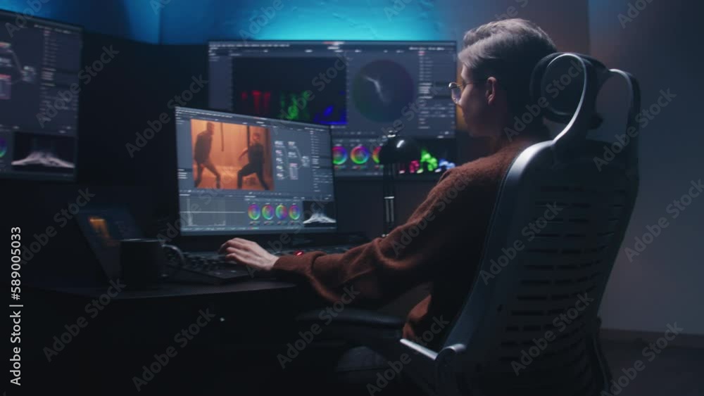 Poster female editor works in studio on computer using color grading control panel and professional video e