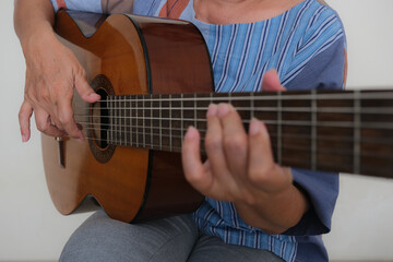 Close up: Female hands playing guitar.