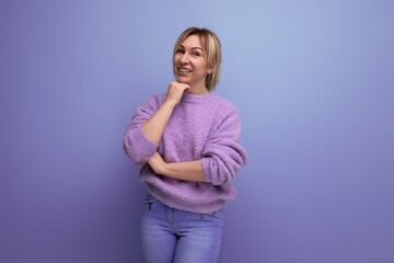 portrait of a cute pleasant blond young woman flirting on a bright plain background