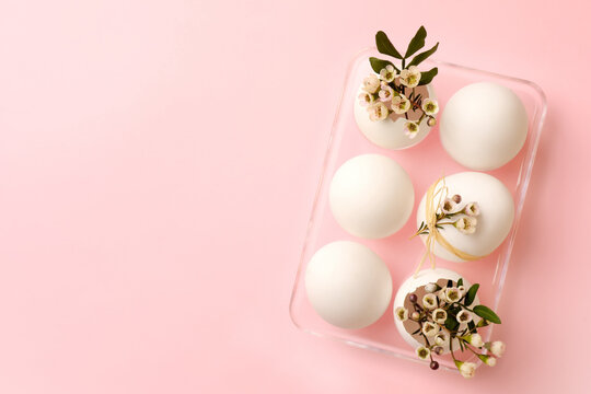 Happy Easter. Festive composition with eggs and floral decor on pink background, top view. Space for text