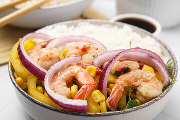 Delicious poke bowl with shrimps, rice and vegetables on white table, closeup