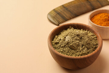 Comb, henna and turmeric powder on beige background, closeup with space for text. Natural hair coloring